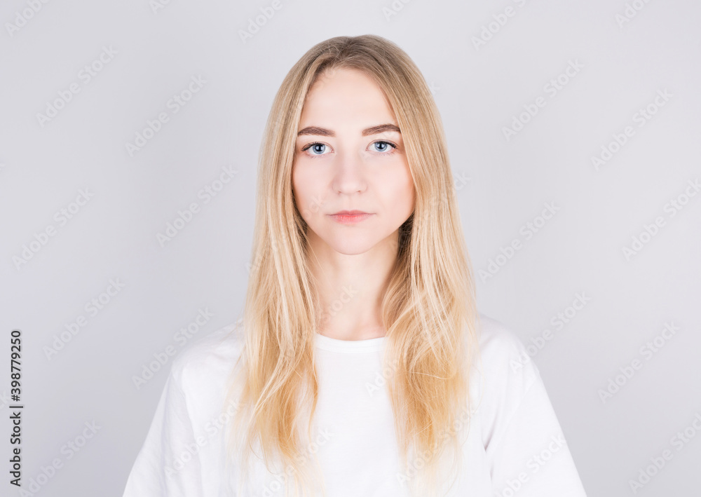 Confident beautiful blonde woman dressed in casual clothes looking seriously at camera. Youth and beauty concept Confident beautiful blonde woman dressed in casual clothes looking seriously at camera. Youth and beauty concept