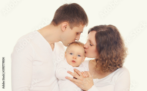 Family portrait of happy mother, father kissing their baby over a white background