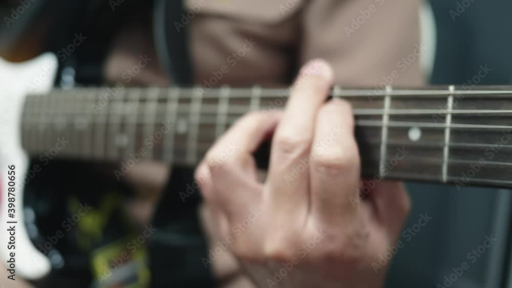 Closeup of a man practicing playing the guitar Spot focus has a beautiful scene Closeup of a man practicing playing the guitar Spot focus has a beautiful scene