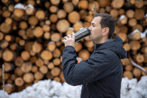 a guy drink a hot the in the snow street mountain