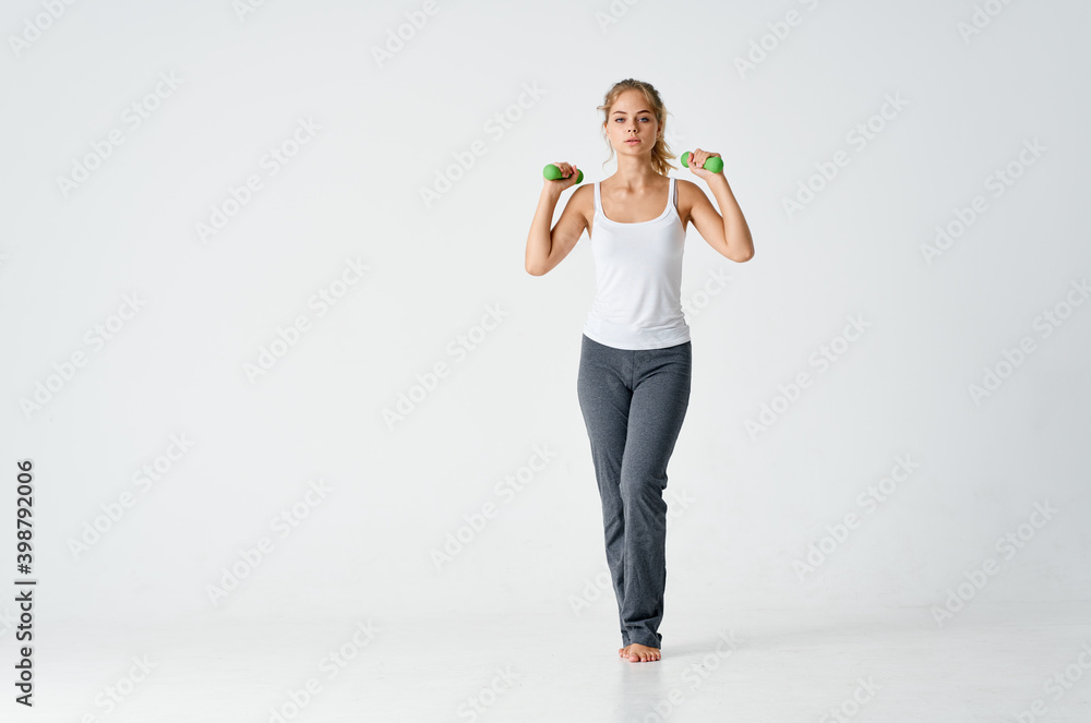 Fototapeta premium woman doing exercises in sportswear on a light background indoors 