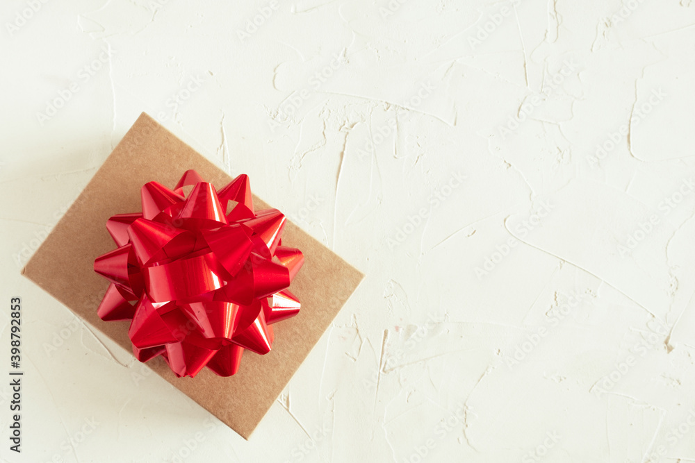 Gift box with big red bow on light background top view flat lay. Holiday concept, birthday gift, new year, Christmas gift box presents Xmas holiday on Valentines day. Copy space. Gift box with big red bow on light background top view flat lay. Holiday concept, birthday gift, new year, Christmas gift box presents Xmas holiday on Valentines day. Copy space.