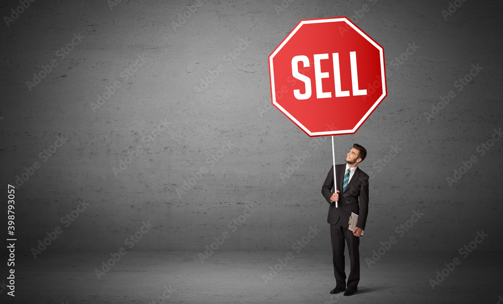 Young business person holding road sign with SELL inscription, new rules concept Young business person holding road sign with SELL inscription, new rules concept