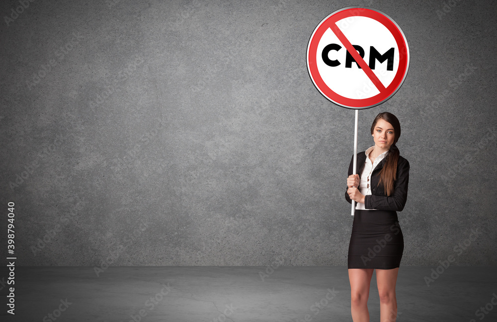 Young business person holdig traffic sign with CRM abbreviation, technology solution concept Young business person holdig traffic sign with CRM abbreviation, technology solution concept
