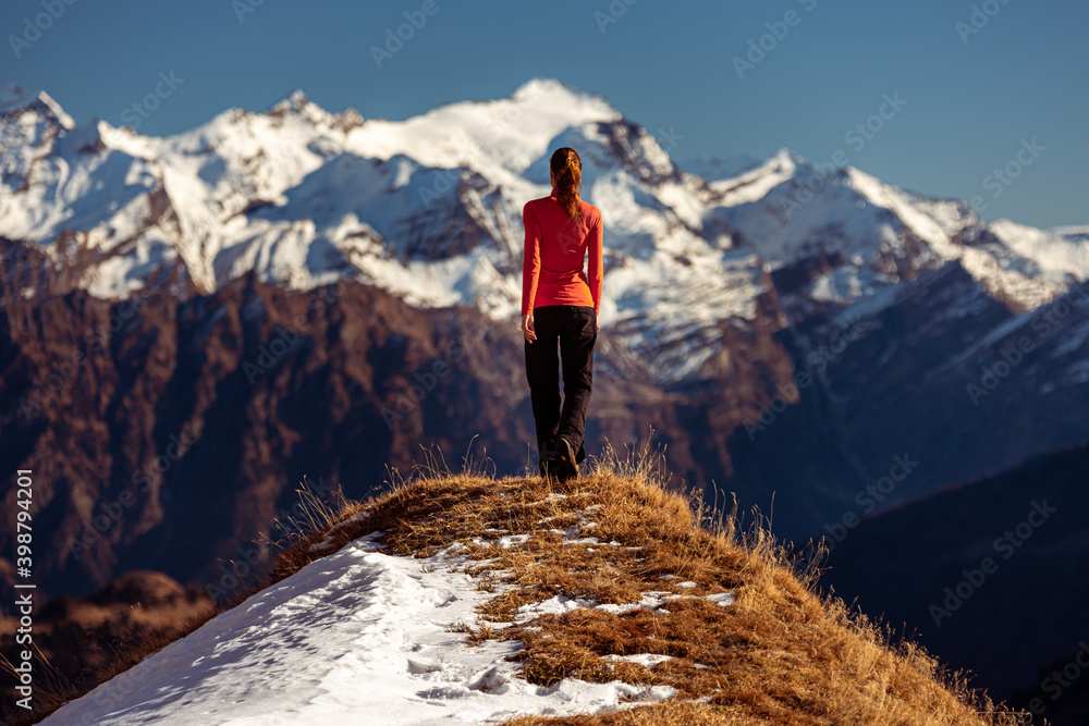 Fototapeta premium woman on top of a mountain observes the view