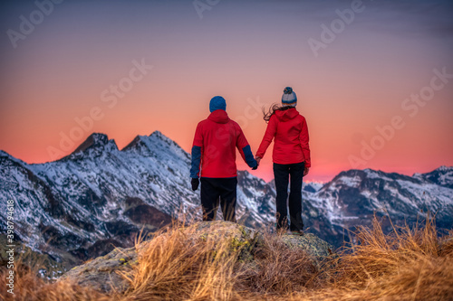 couple of people watch the sunset from a mountain © criskorah