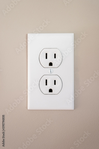 A 115amp duplex electrical white wall outlet with a face plate