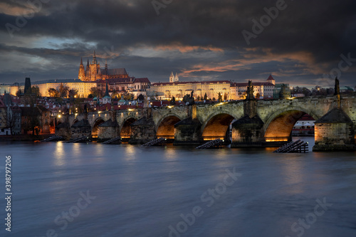 prague castle and charles bridge and st. vita church lights from street lights are reflected on the surface of the vltava river in the center of prague at night in the czech republic © svetjekolem