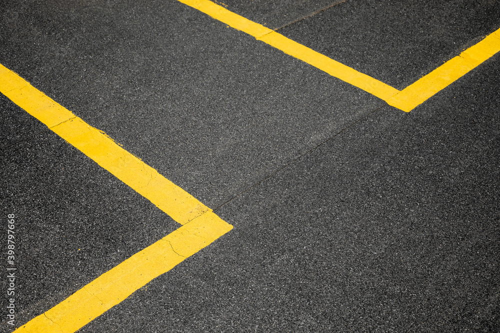 Abstract texture composition in the form of yellow boundary warning lines painted with paint on a dark gray background. The natural texture of the bituminous coating on the roof of the house.