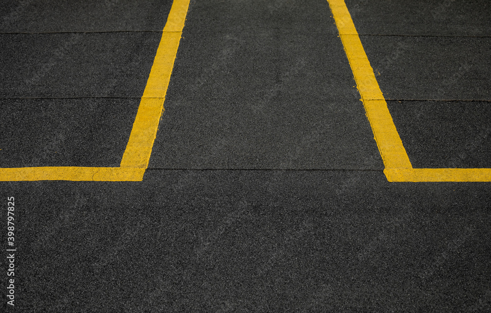 Abstract texture composition in the form of yellow boundary warning lines painted with paint on a dark gray background. The natural texture of the bituminous coating on the roof of the house. Abstract texture composition in the form of yellow boundary warning lines painted with paint on a dark gray background. The natural texture of the bituminous coating on the roof of the house.