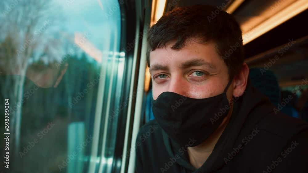 Travel using rail transport. He looks out the window for the movement of the road. Spending time on the road. A male passenger sits near the train window on a journey. Travel using rail transport. He looks out the window for the movement of the road. Spending time on the road. A male passenger sits near the train window on a journey.