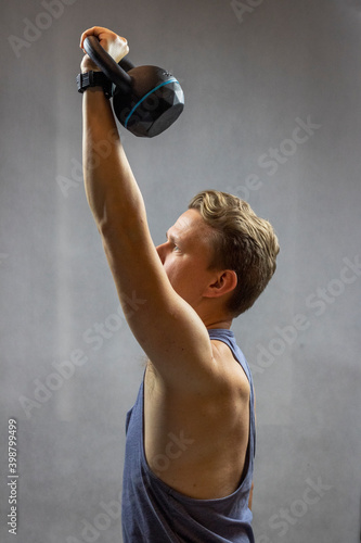 Caucasian man holding a black kettlebell