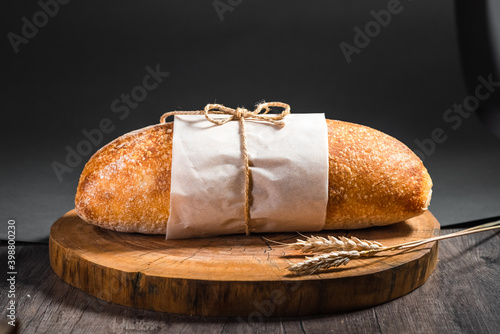 A loaf of traditional ciabatta on a wooden tray on the table. Craft bread concept