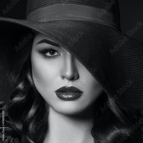 Portrait of a beautiful woman with blue lips in a hat, toned in color of the year 2020, classic blue. © popovich22