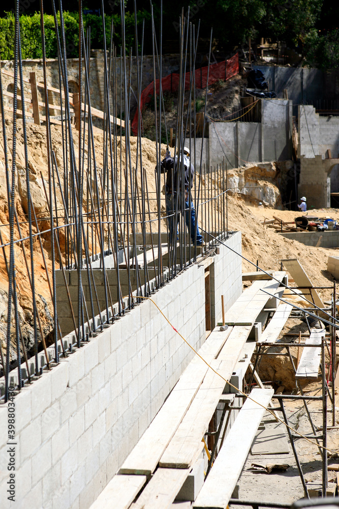 Foto de Installing rebar extensions to a concrete block retaining wall
