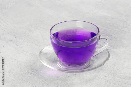 Butterfly pea flower tea is brewed in a glass teapot and served into a transparent cup. Blue herbal tea. photo