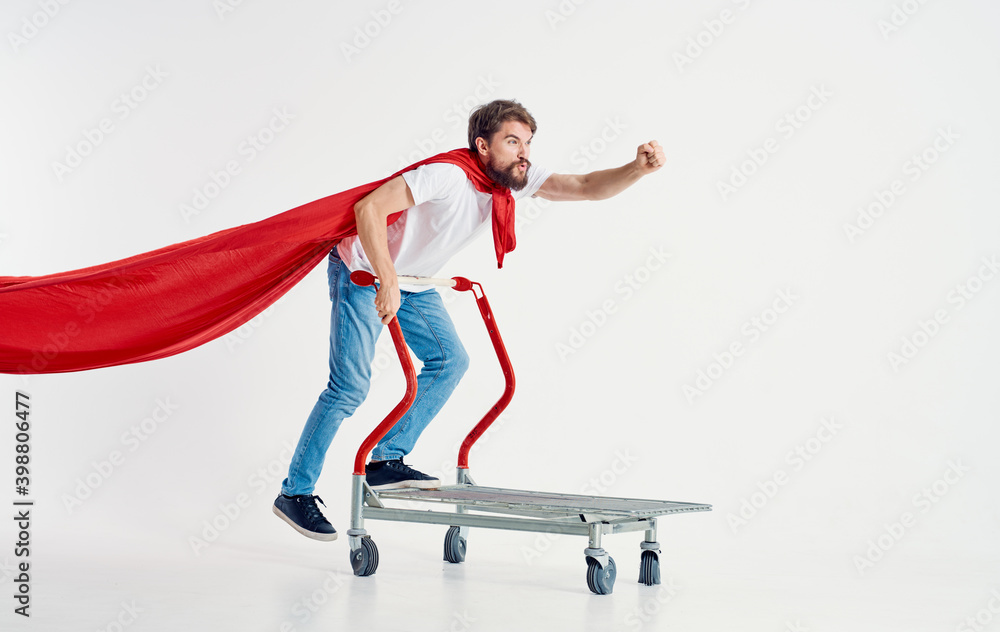 man in a red coat jeans t-shirt cargo trolley light background Copy Space