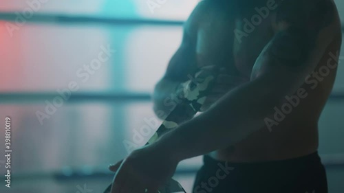 Boxer in the boxing gym. Bandages his hands. Sparring in the ring. Boxer jumping rope. Exercise with ropes. Round one. Fog in the ring. Zetsky sport. Beautiful backlight. World boxing champion.

