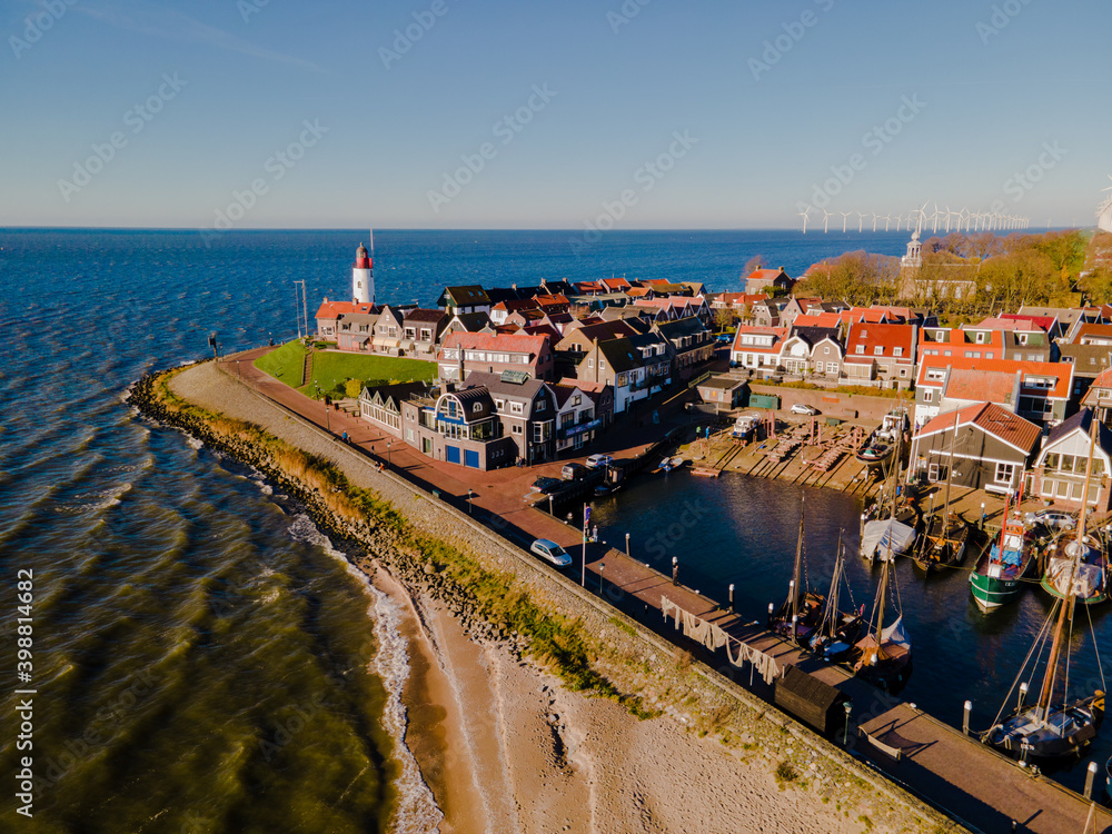 Urk lighthouse with old harbor during sunset, Urk is a small village by the lake Ijsselmeer in the Netherlands Flevoland area. beach and harbor of Urk - obrazy, fototapety, plakaty 