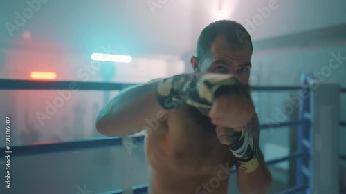 Boxer in the boxing gym. Bandages his hands. Sparring in the ring. Boxer jumping rope. Exercise with ropes. Round one. Fog in the ring. Zetsky sport. Beautiful backlight. World boxing champion.

 photo