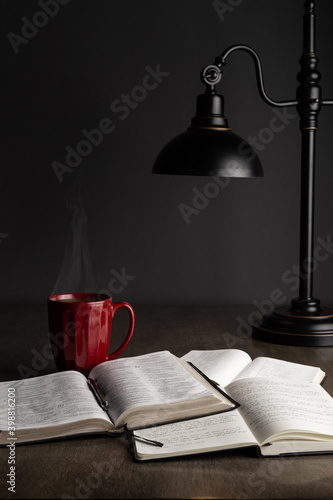 Fotografiet Bible study with notes, book of prayer, and red coffee mug under a lamp