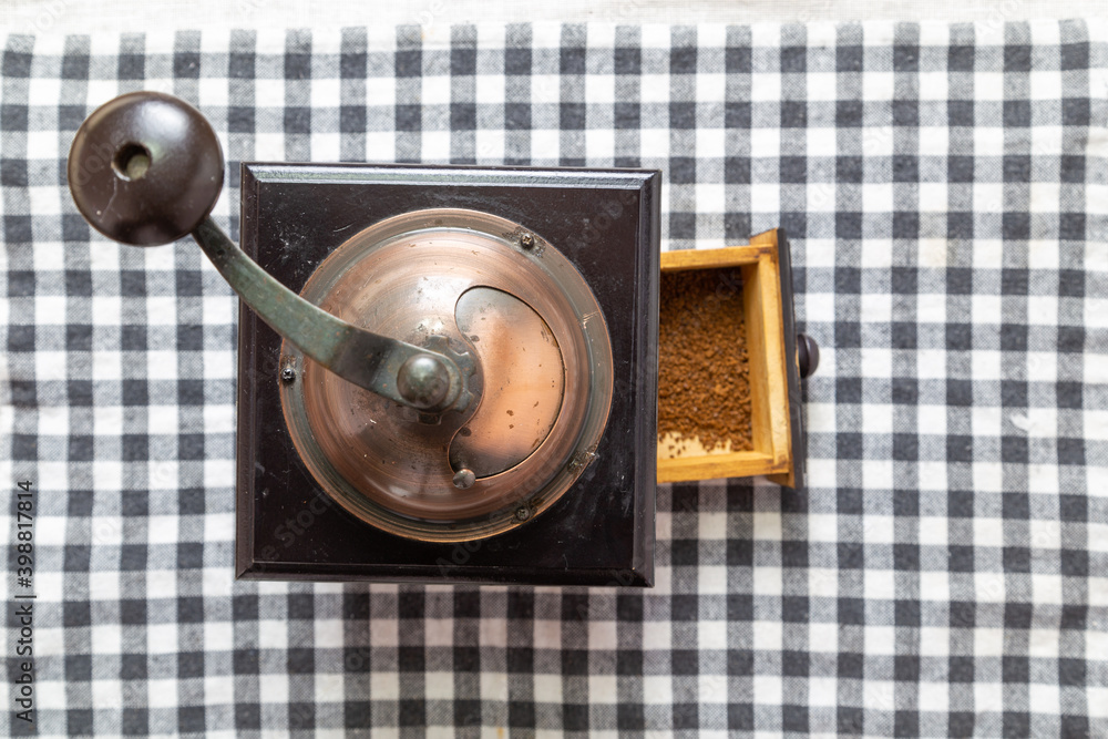 Antique coffee grinder on table mat, top view