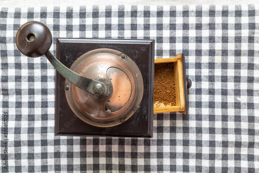 Antique coffee grinder on table mat, top view Antique coffee grinder on table mat, top view