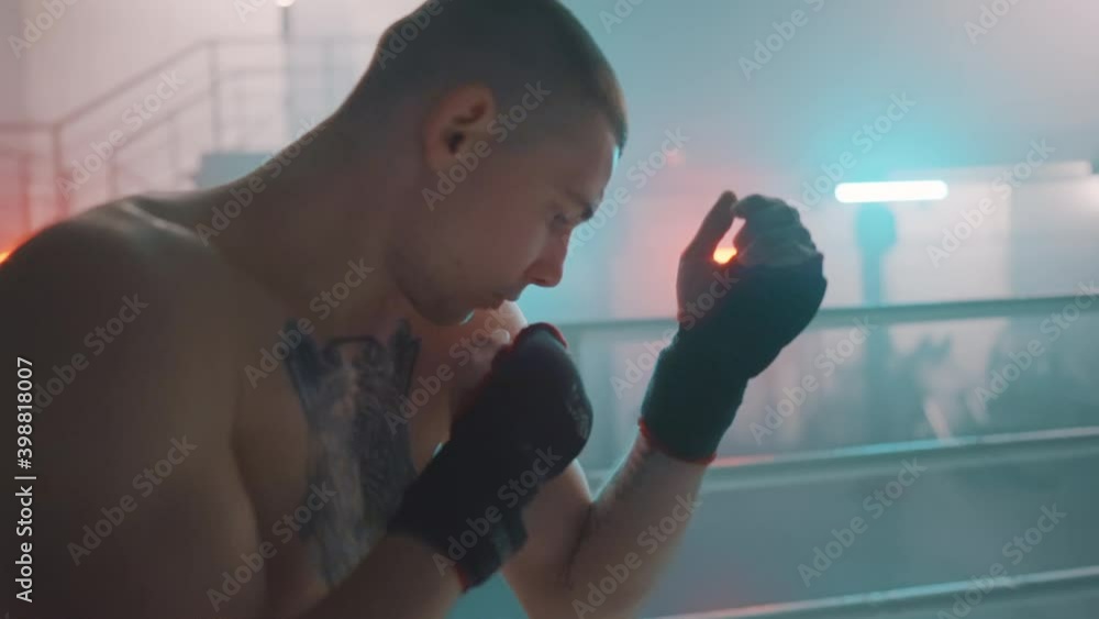Boxer in the boxing gym. Bandages his hands. Sparring in the ring ...
