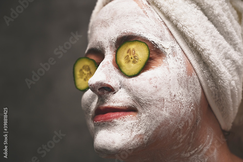 A woman applies a face mask and uses cucumber slices to solve skin problems around the eyes. An ecological, vegan, vegetarian way of life. Self-care and lifestyle, solving skin issues.