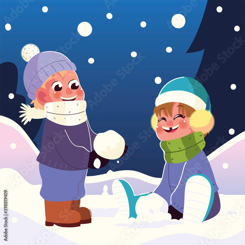 happy kids with earmuffs and scarf playing with snowball