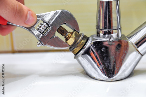 Plumber fixes crane with wrench