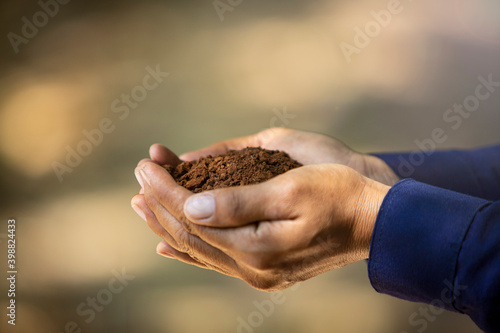 Farmer holding pile of arable soil.