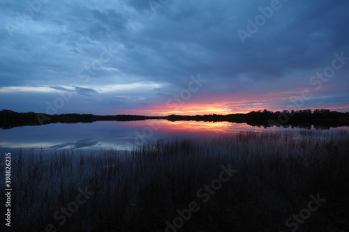 Colorful sunrise cloudscape reflected on tranquil water of Nine Mile Pond in Everglades National Park, Florida.