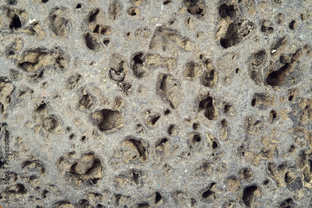 Rough weathered stone surface with erosion and holes, close up Rough weathered stone surface with erosion and holes, close up
