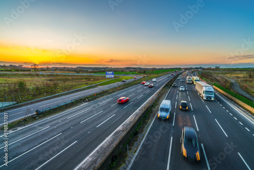 Colorful sunset at M1 motorway near Flitwick junction with blurry cars in United Kingdom