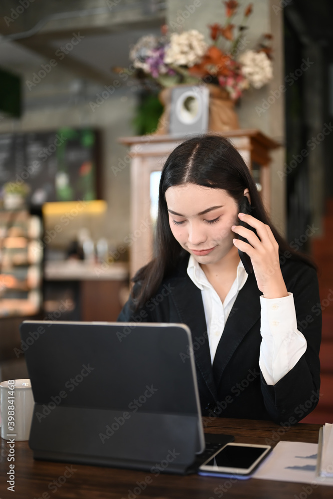 Portrait of businesswoman in black suit talking on mobile phone and working at modern office. Portrait of businesswoman in black suit talking on mobile phone and working at modern office.