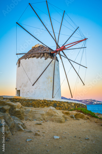Traditional white windmill near the sea coast at sunrise
