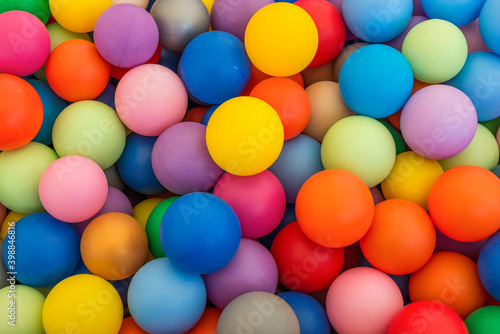 Full frame of multicolored plastic balls in the ball pit (ball crawl). Lots of colorful balls for children to play in the water park. Toy dry pool for kids © Damian Pawlos