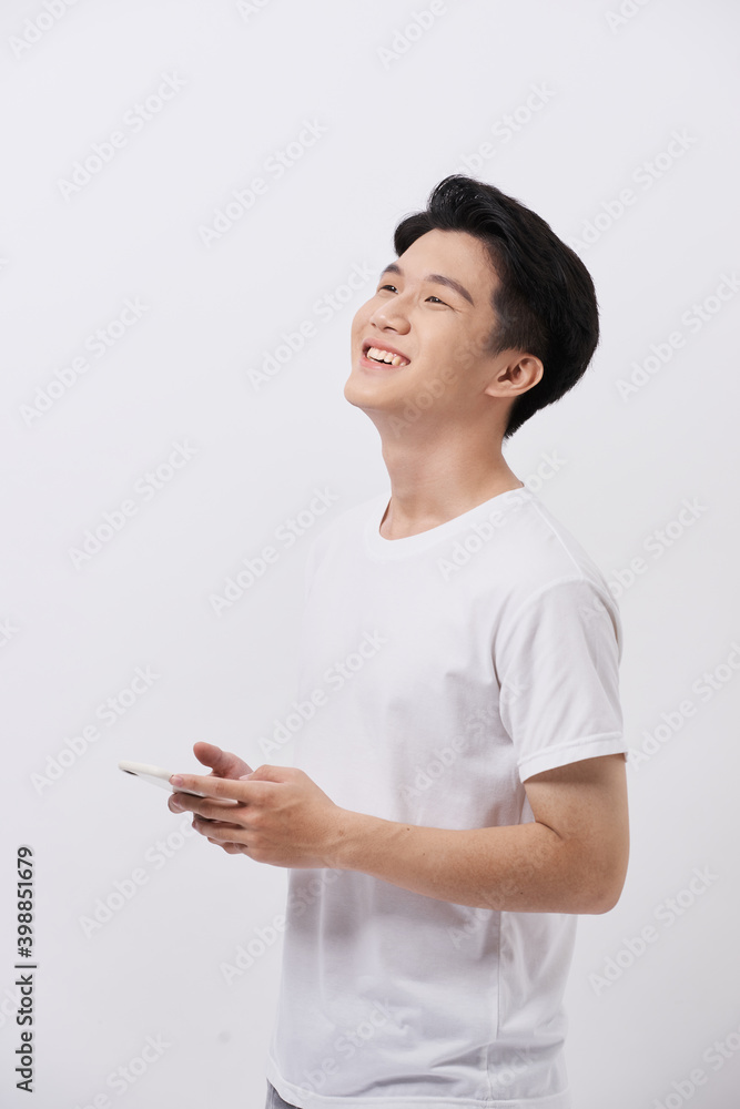 Handsome smiling man in white t-shirt holding smartphone and typing sms. Handsome smiling man in white t-shirt holding smartphone and typing sms.