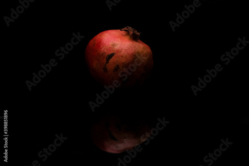 Pomegranate with reflection on dark background