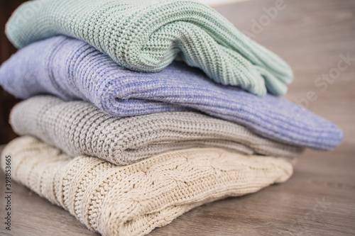 a stack of warm cozy woolen sweaters jersey jumpers for the winter