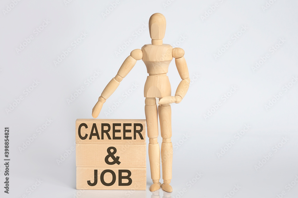 Wooden man shows with a hand text CAREER AND JOB concept on the wooden block Wooden man shows with a hand text CAREER AND JOB concept on the wooden block