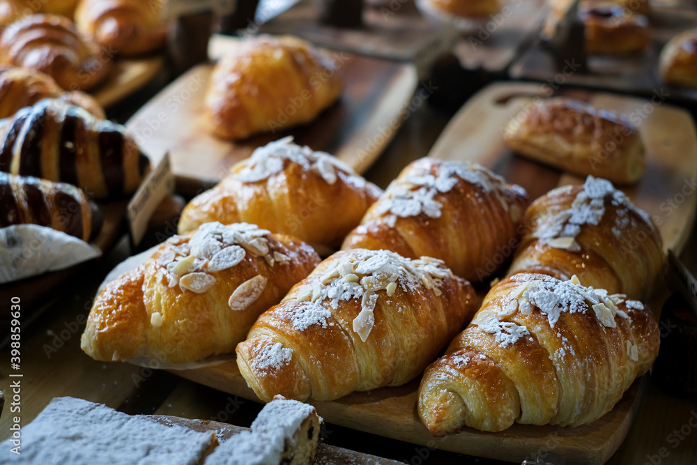 Fresh Croissant. Many fresh bread on a wooden table. Many diverse bread on a wooden board. Variety of breads displayed at bakery shop. Fresh from the oven pastry on wooden table. Fresh Croissant. Many fresh bread on a wooden table. Many diverse bread on a wooden board. Variety of breads displayed at bakery shop. Fresh from the oven pastry on wooden table.