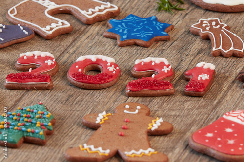 Painted Christmas gingerbread cookies on a wooden table. Gingerbread numbers 2021