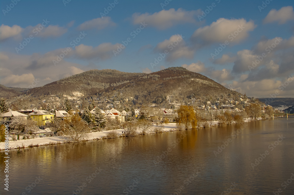 Winter with snow in old downtown, castle and main city bridge in Heidelberg, Germany, with blue cloudy sky and sunny day.