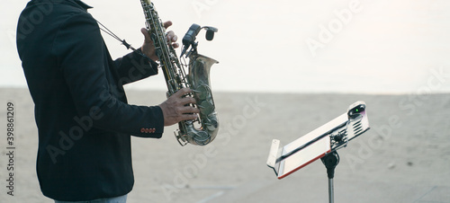 Photography Musician man playing saxophone on the beach.