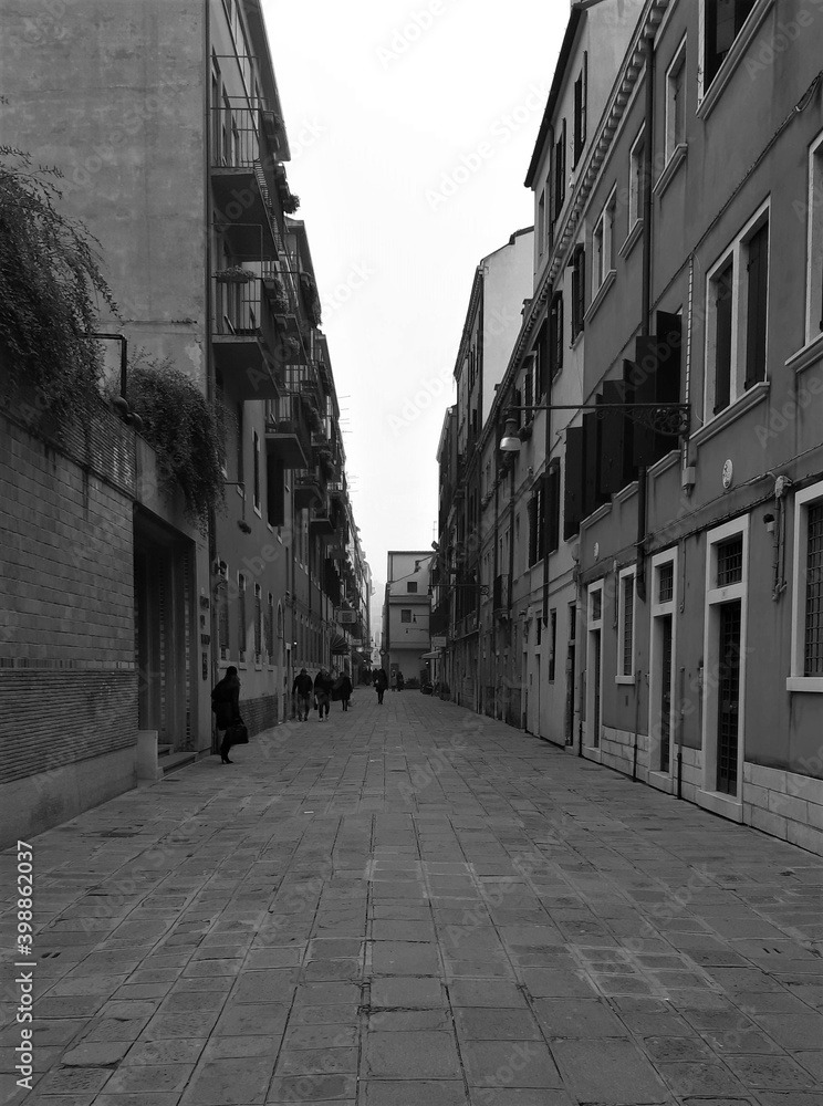 Venice, Italy, January 27, 2020 evocative black and white image of a typical calle of Venice on a bad day
