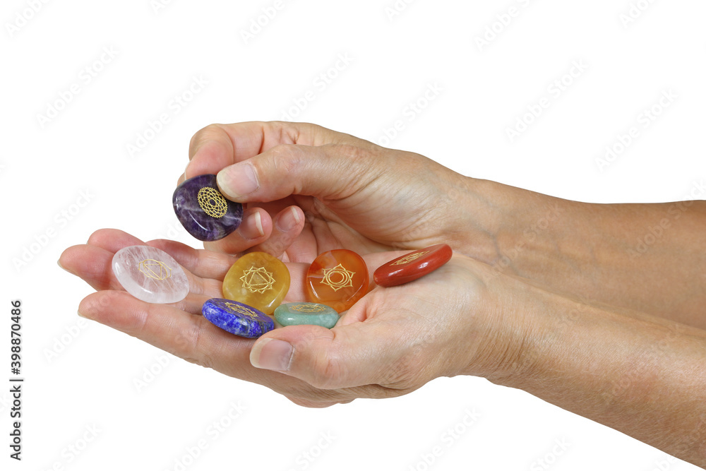 Offering third eye chakra healing stone - female holding red, orange, yellow, green, blue, indigo and clear quartz chakra symbol engraved crystals against white background with copy space
Offering third eye chakra healing stone - female holding red, orange, yellow, green, blue, indigo and clear quartz chakra symbol engraved crystals against white background with copy space
