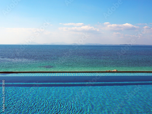 sea view swimming pool, blue green ocean and bright blue sky with clouds