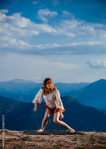 Portrait of a fit, young hip hop dancer while dancing in red skirt on mountain